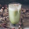 Cup of matcha tea with soft foam created with the electric matcha frother