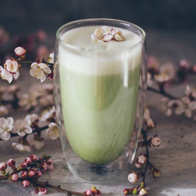 Cup of matcha tea with soft foam created with the electric matcha frother