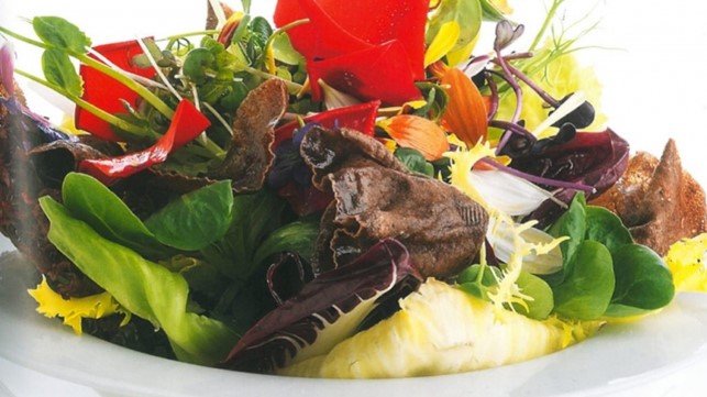 Insalata di erbe con fiori eduli e chips di riso al te nero Puer
